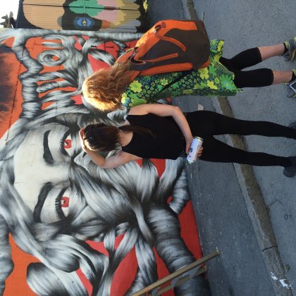 Cool female street artist checking her work